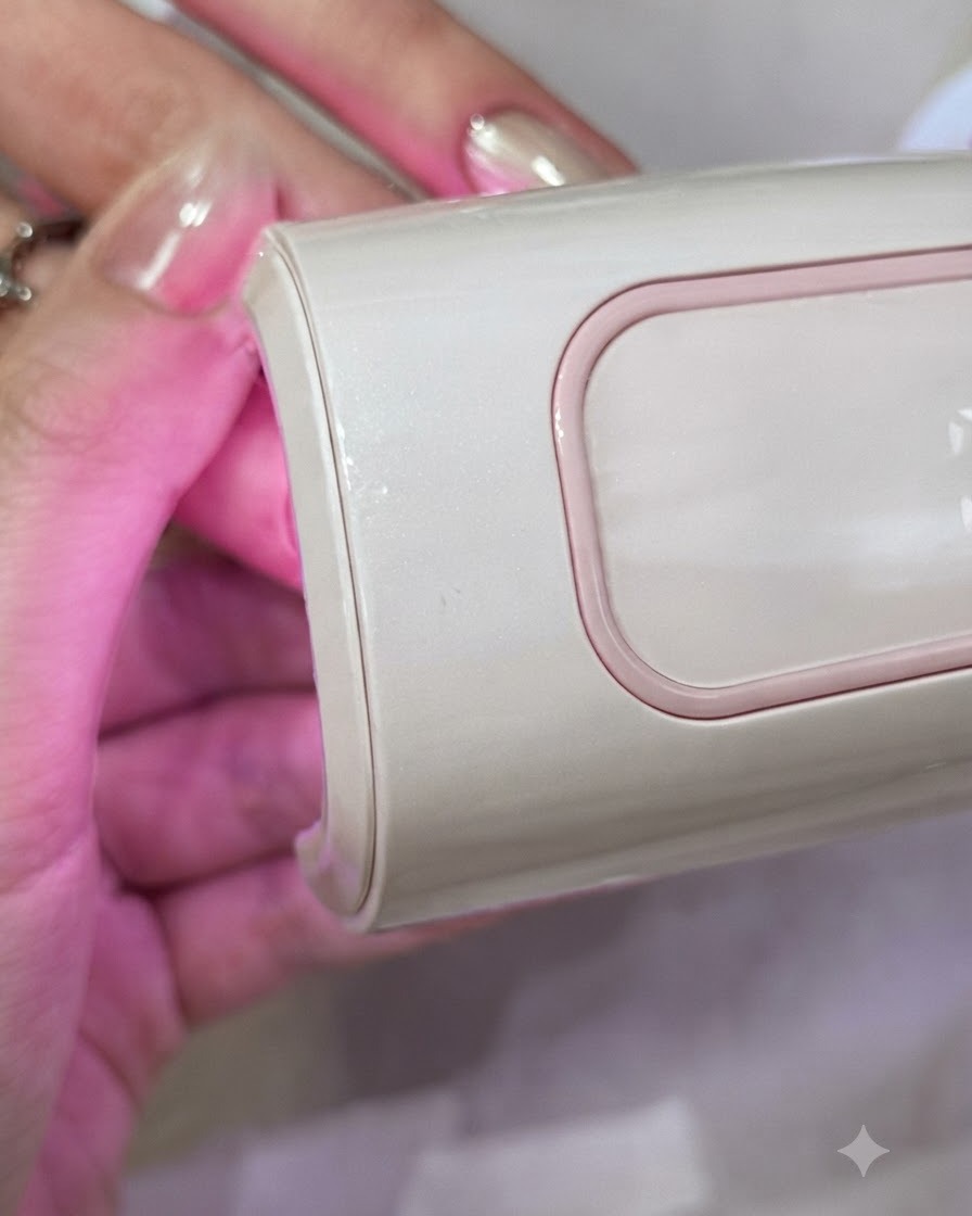 Eine Hand, die während des Gel-Aushärtungsprozesses in der Nähe einer rosa UV/LED-Lampe positioniert ist.