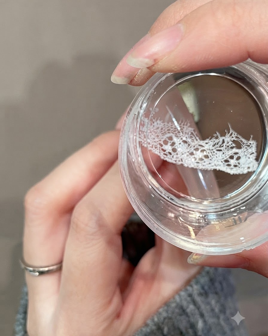 Ein klarer Geleebesen-Stamper überträgt ein zartes weißes Spitzendesign auf den oberen Teil einer Nagelspitze.
