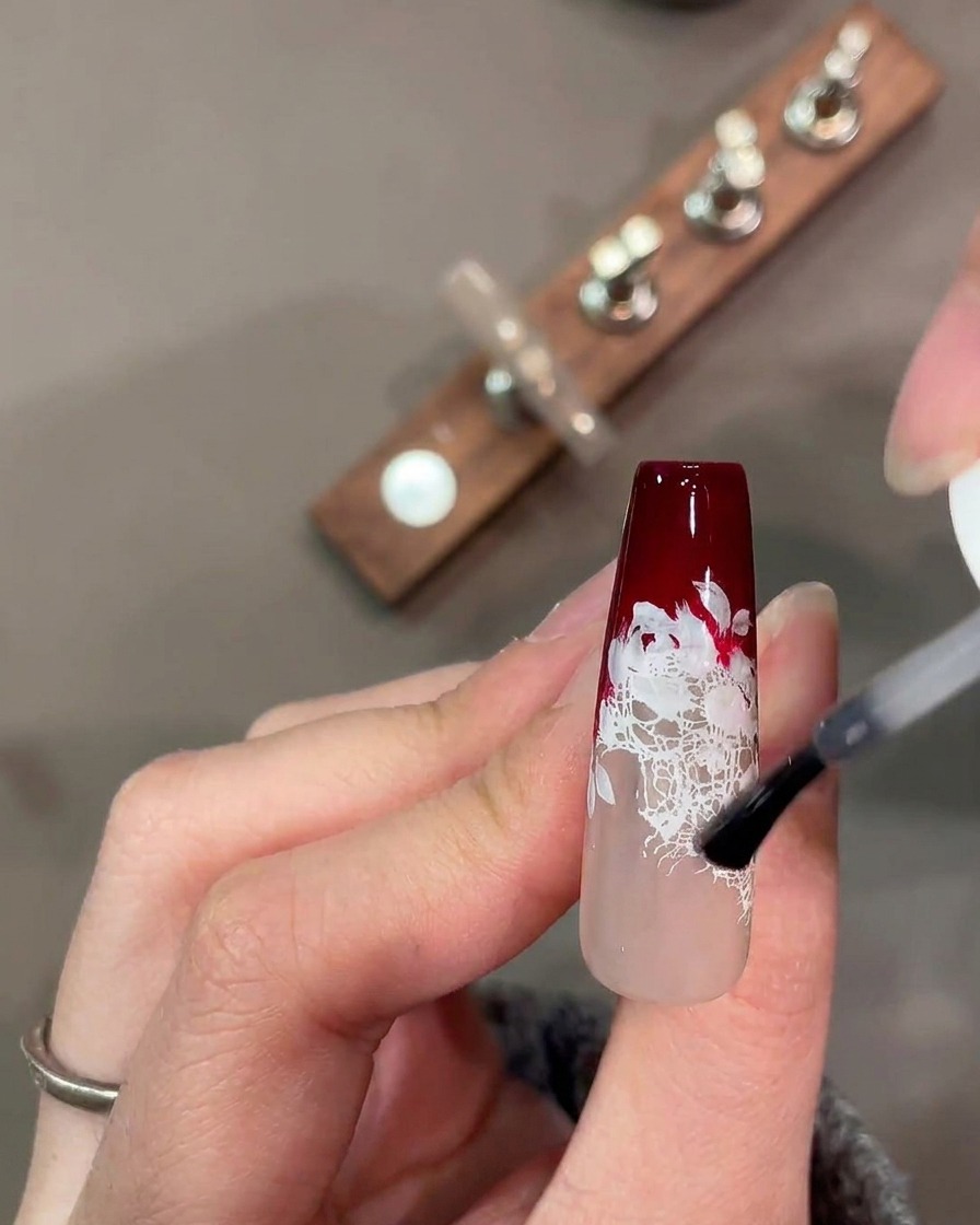 Eine Aquarellpalette mit gemischten roten, grünen und rosa Pigmenten für Nagelkunst.
