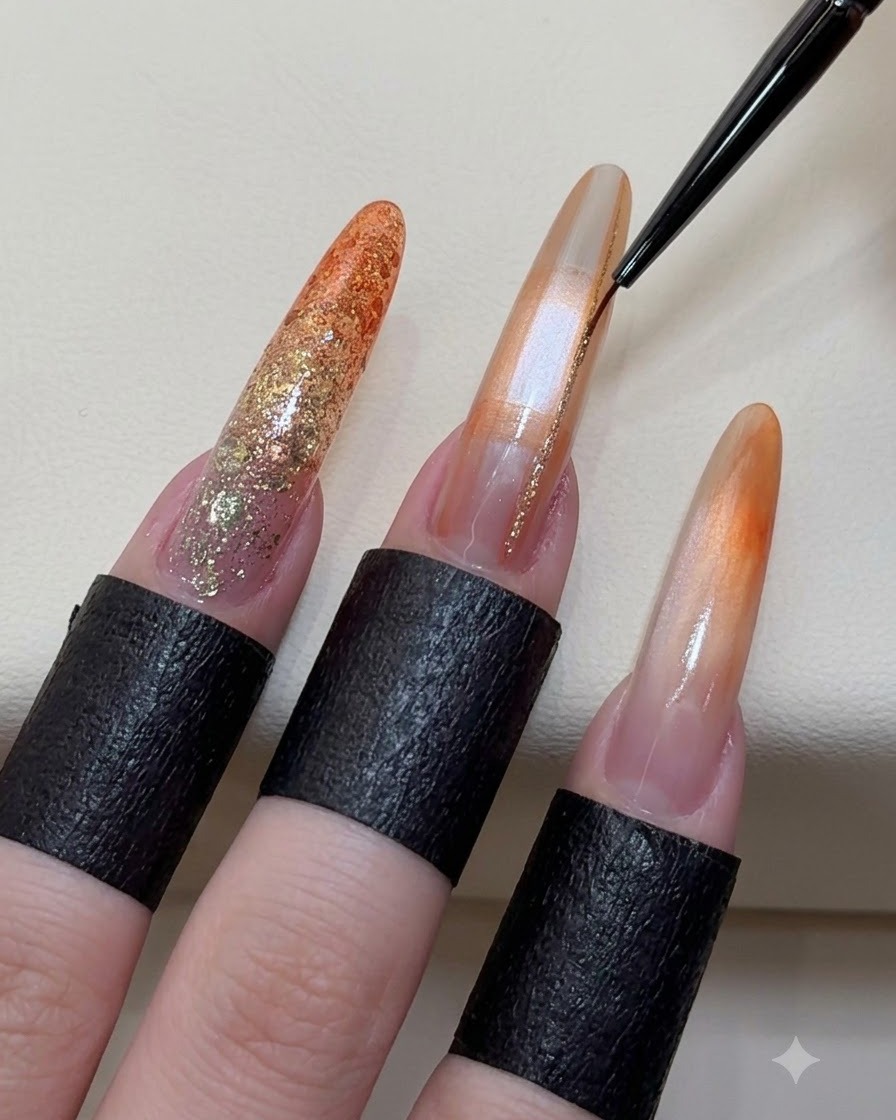 Ein feiner Liner-Pinsel trägt funkelnde Champagner-Gold-Linien auf einen verzierten Gel-Nagel auf.