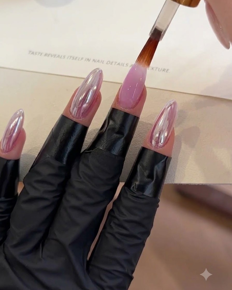 Ein Pinsel trägt eine klare Top-Coat-Schicht auf einen lila Gel-Nagel auf.