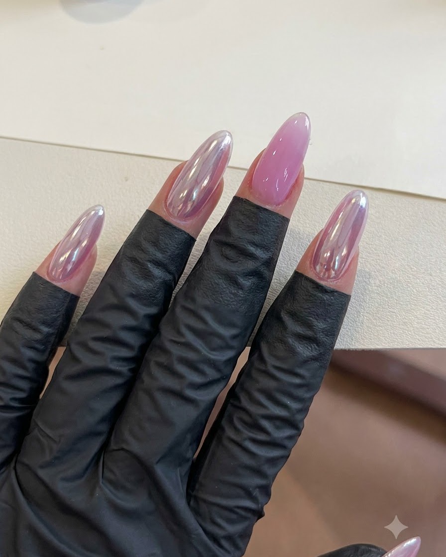 Eine Hand mit fertigen lila Gel-Nägeln ruht während der Aushärtungsphase unter Beleuchtung.