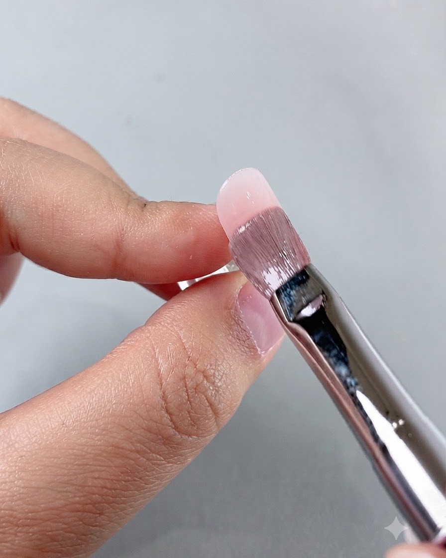 Ein Manikürepinsel glättet Produkt in der Nagelhautregion während der Nagelapplikation.