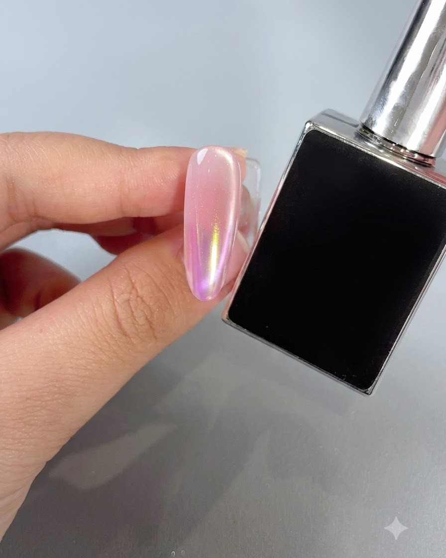 Ein manikürter Nagel mit einem warmen Aurora-Puder-Farbverlauf im Sunset-Ton neben einer Lackflasche.