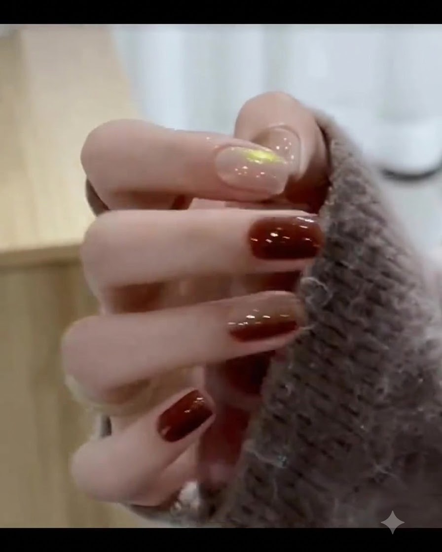 Ein Pinsel trägt ein sattes karamellbraunes Gel auf den Spitzenbereich des Fingernagels auf.