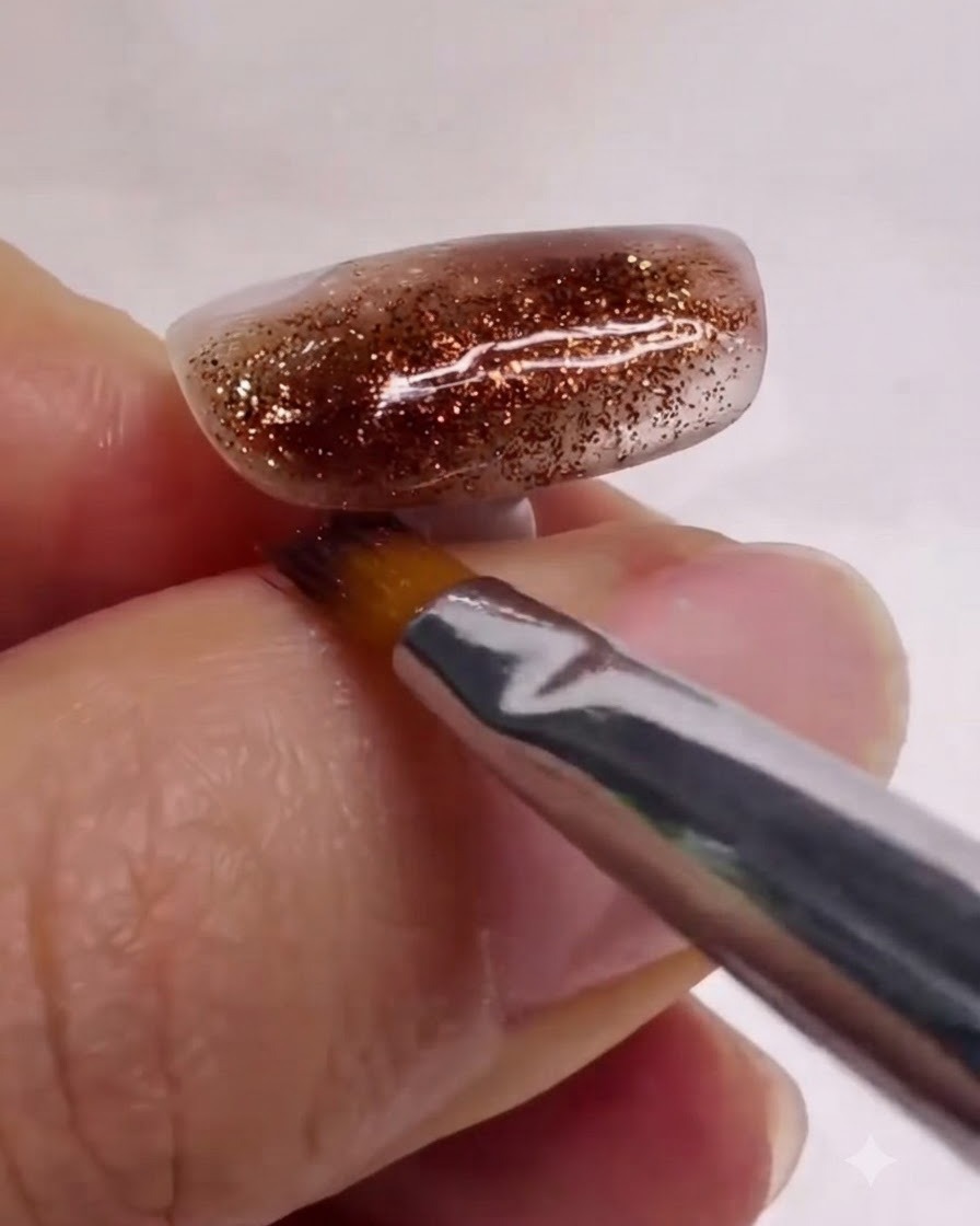 Ein sauberer Nail-Art-Pinsel glättet und verblendet weiße und braune Marmorschichten auf einem texturierten Nagel sanft.