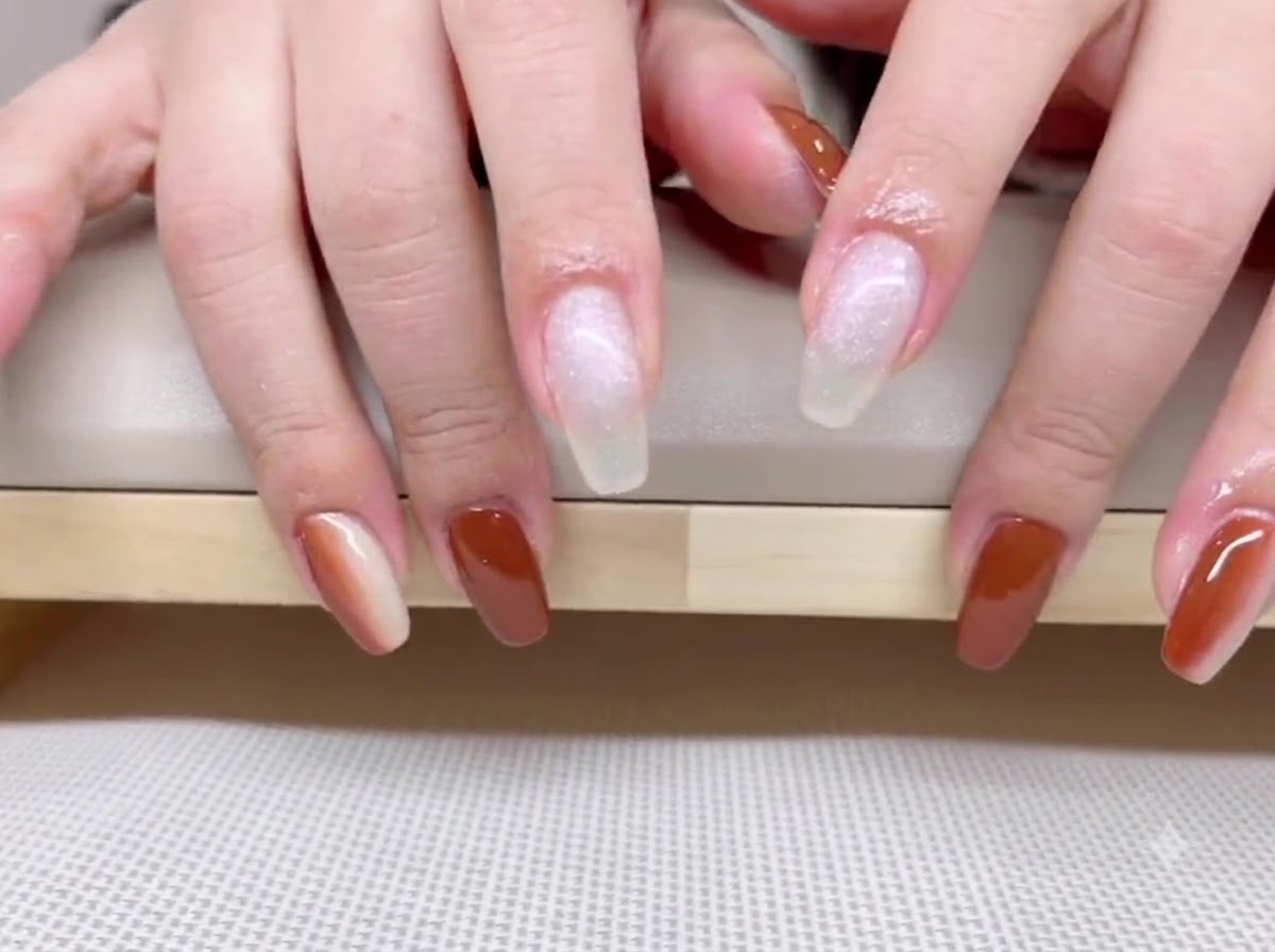 Ansicht von Händen mit sattem karamellbraunen Gel-Nagellack auf Daumen, Ring- und kleinen Finger.