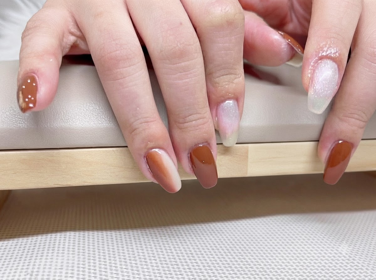 Detaillierte Makroaufnahme der fertigen Karamel-Bernstein-Gelnägel mit Lichtreflexion unter Top Coat.