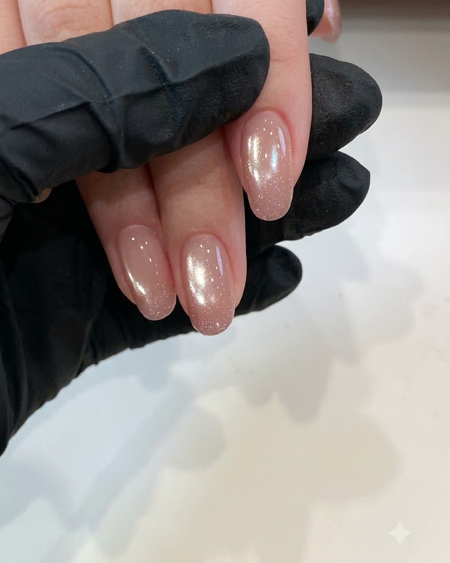 Nahaufnahme von sauberen kurzen Naturnägeln, die unter Studiobeleuchtung für die Base-Coat-Vorbereitung bereit sind.