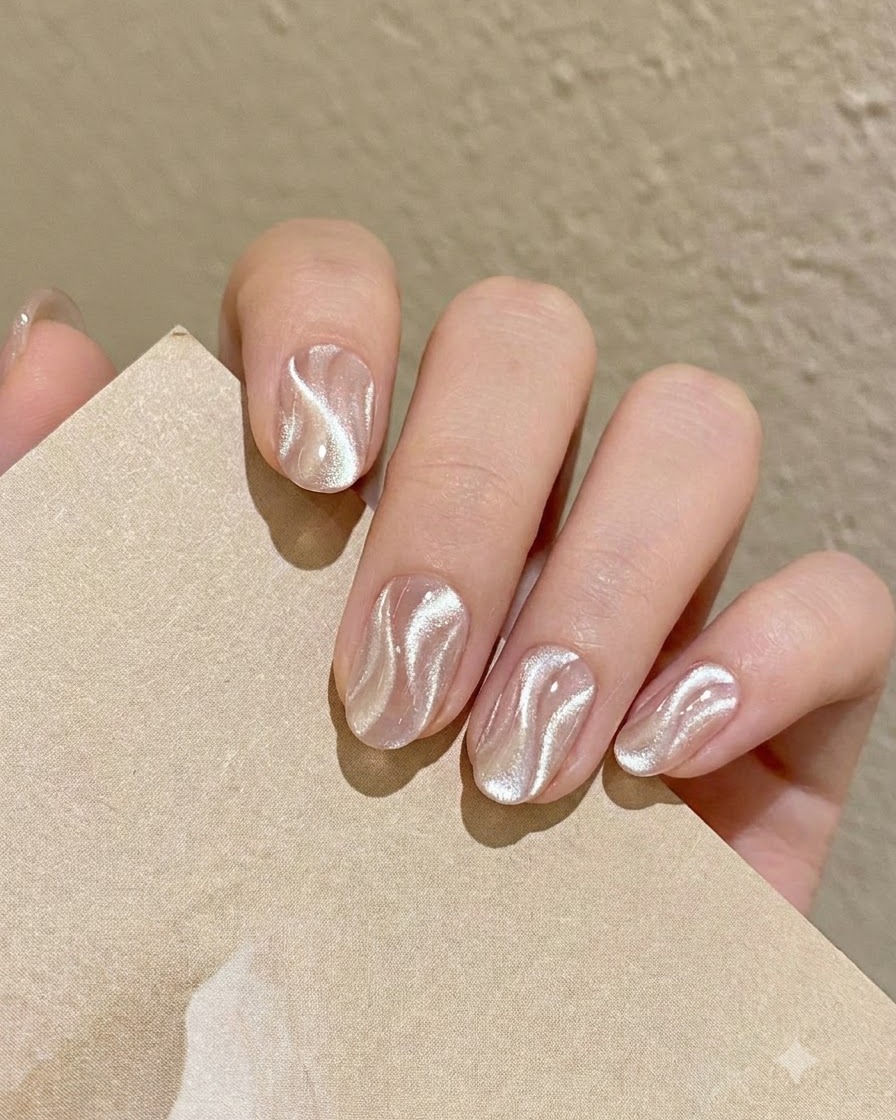 Ein feiner Nail-Art-Liner-Pinsel nimmt eine kleine Menge schimmerndes, silbernes Cat Eye Gel von der Palette auf.