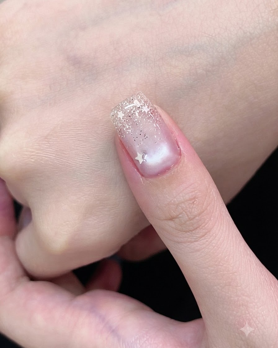 Ein Gelpinsel bedeckt einen Fingernagel mit einem transparenten weißen Cat-Eye-Lack.