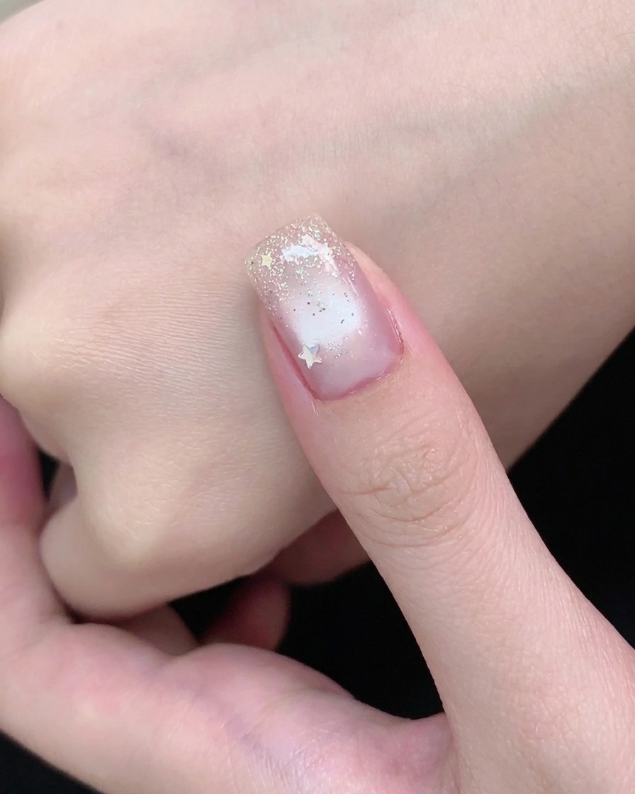 Ein Stabmagnet hält eine helle Schimmerlinie konzentriert in der Mitte eines Cat-Eye-Gelnagels.