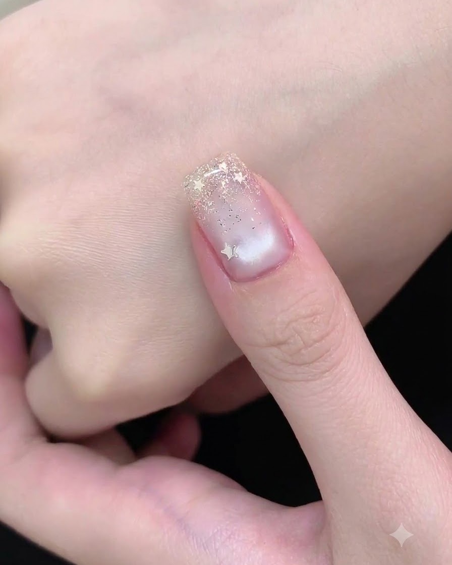 Ein Nail-Art-Pinsel tupft feinen Silberglitter auf die Nagelspitze, um einen Verlauf zu erzeugen.