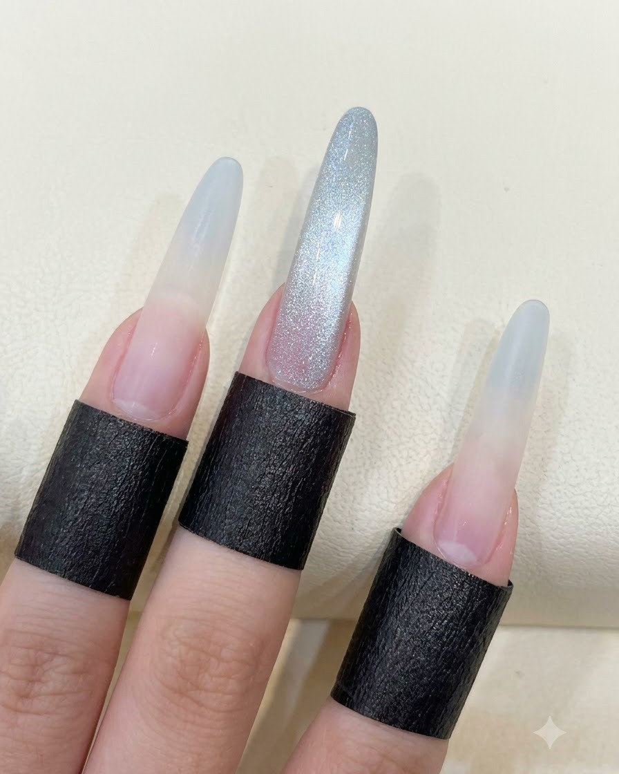 Eine Hand zeigt lange mandelförmige Nägel mit der vollendeten Glasperlen-Cat-Eye-Reflektion.