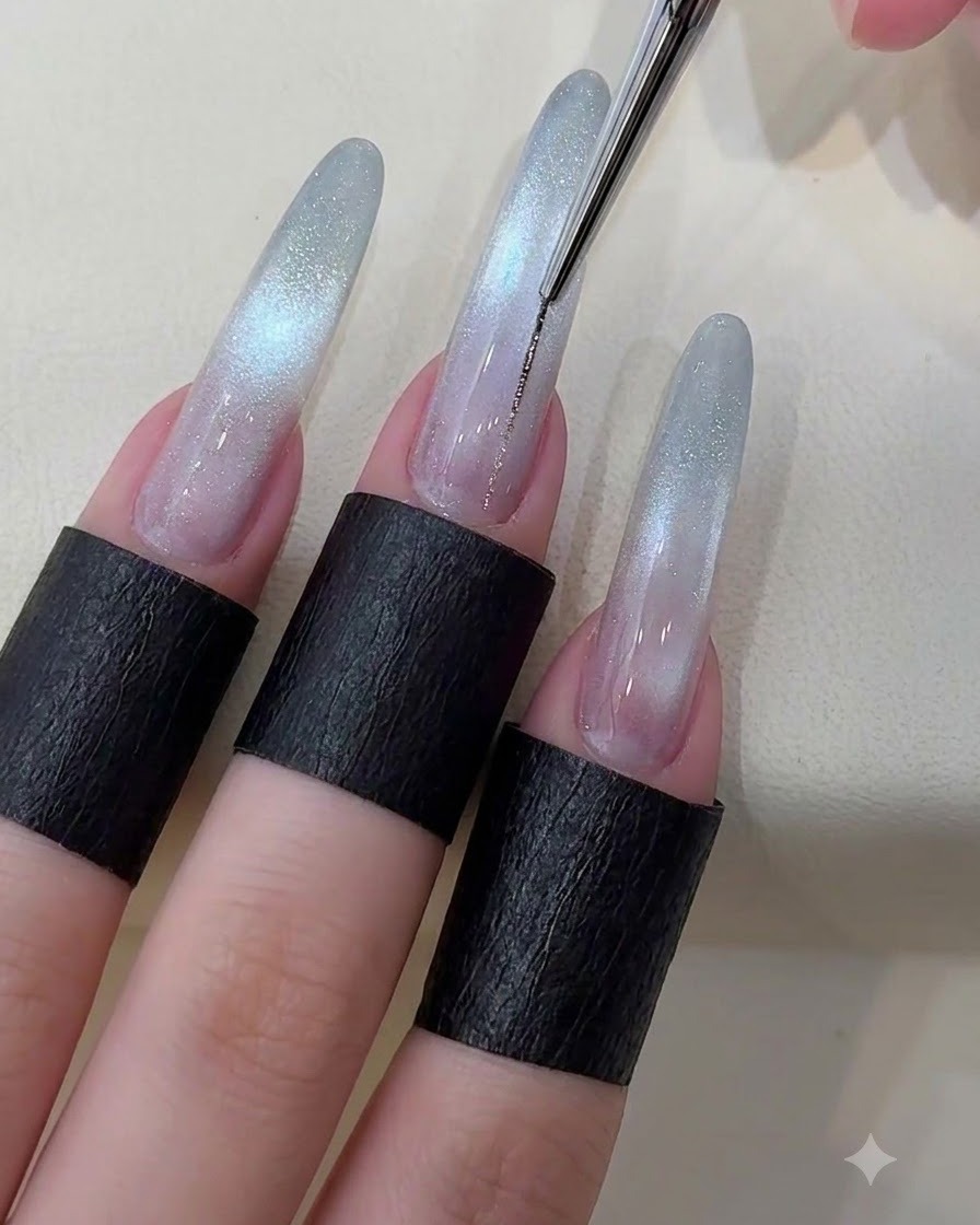 Ein feiner Liner-Pinsel zieht eine dünne metallisch silberne Linie die Mitte eines Sternen-Cat-Eye-Nagels hinunter.