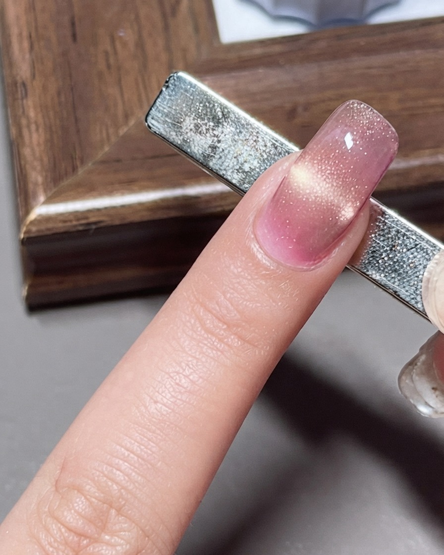 Ein breiter Magnet wird unter der Nagelspitze platziert, um ein Shrimp-Line-Cat-Eye-Muster zu erzeugen.