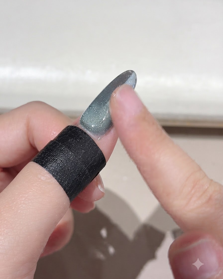 Ein Finger wischt überschüssiges, loses Magic Powder von einer Nageloberfläche mit Farbverlauf ab.