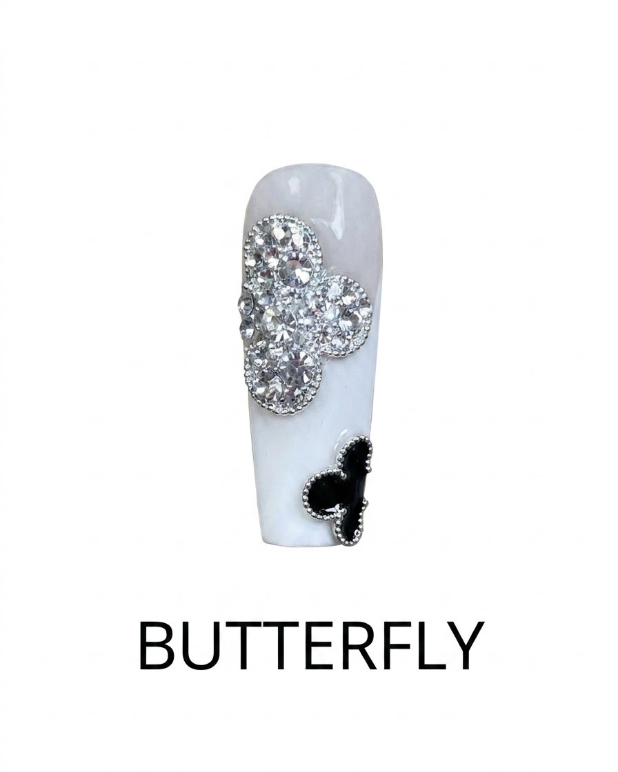 Nahaufnahme eines fertigen Nageldesigns mit einem silbernen Strass-Kleeblatt und einem schwarzen Kleeblatt-Akzent.