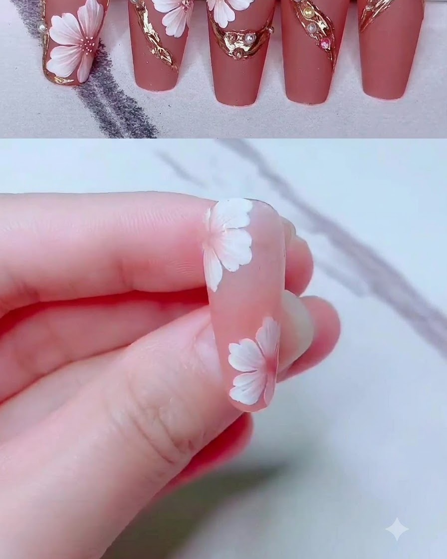 Ein feiner Liner-Pinsel zeichnet filigrane Gold-Gellinien um ein florales Nagelkunst-Design.