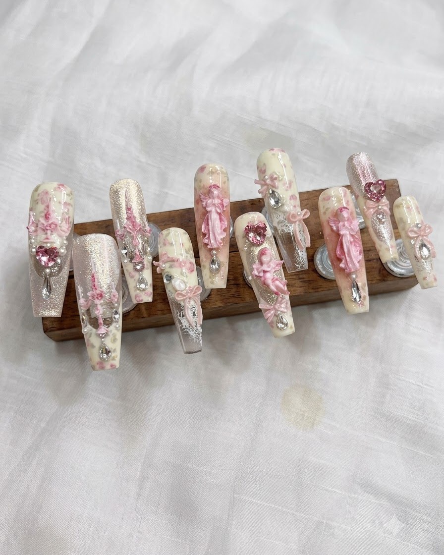 Ein Nagelpinsel verteilt eine helle, cremeweiße Gelfarbe gleichmäßig auf dem Nagel.