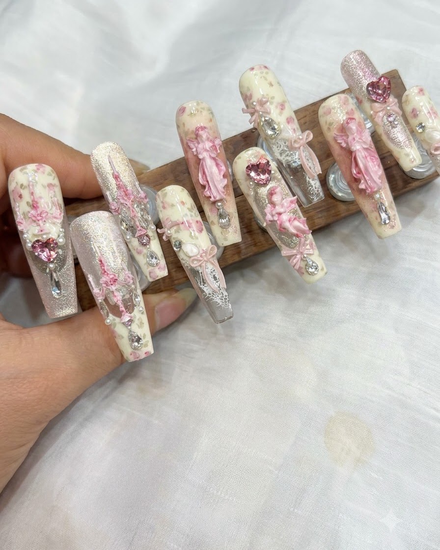 Ein Schwammapplikator tupft rosa Blush-Gel auf die Spitze eines manikürten Nagels.