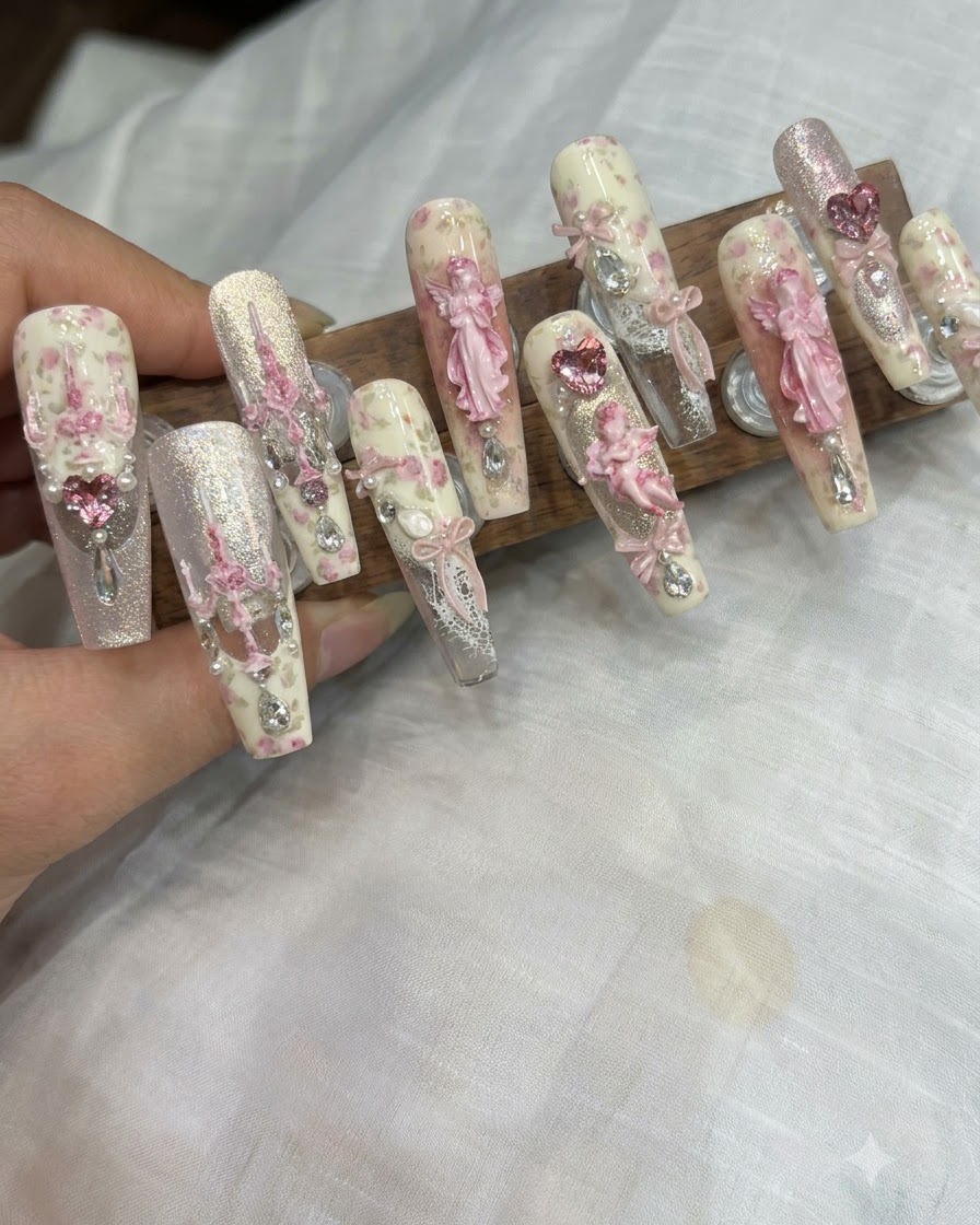 Ein feiner Detailpinsel trägt winzige Glitzerpunkte auf die Mitte eines verzierten Nagels auf.