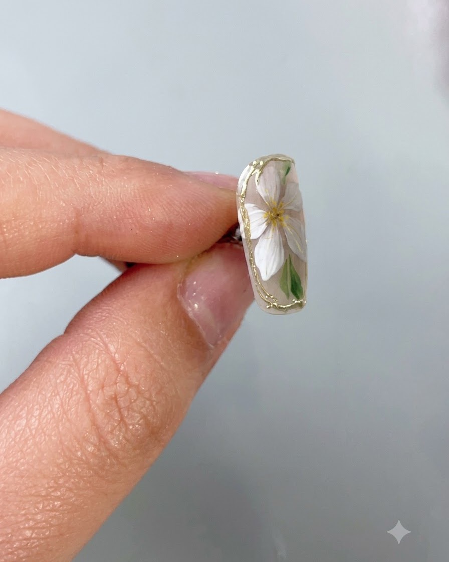 Ein feiner Nail-Art-Pinsel trägt einen klaren Schutz-Top-Coat präzise über einem zarten Goldchrom-Rand auf einem Nude-Basisnagel auf.