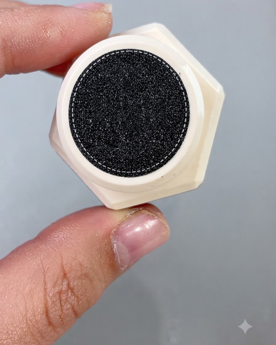 Ein Nagellackpinsel trägt ein schimmerndes Cantaloupe-Cat-Eye-Gel gleichmäßig auf eine künstliche Nagelspitze auf.