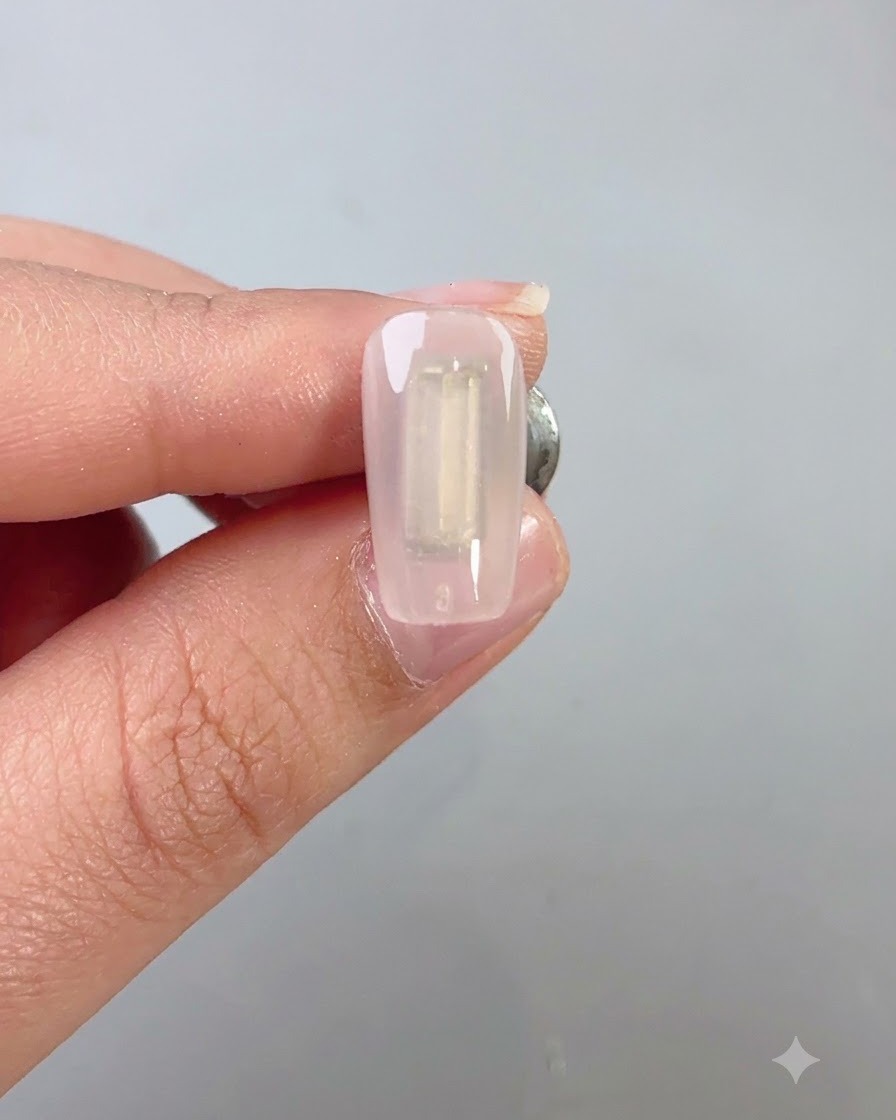 Ein Nagelpinsel trägt eine Schicht dunkelgrünen Wilderness-Cat-Eye-Gels gleichmäßig über einen Nagel auf.