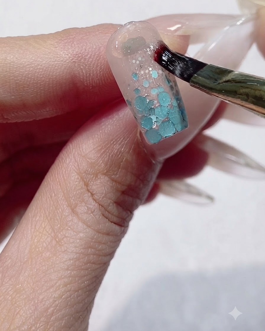 Ein feiner Pinsel trägt dickes Modelliergel in U-Form um den Nagelhautbereich eines Nagels auf.
