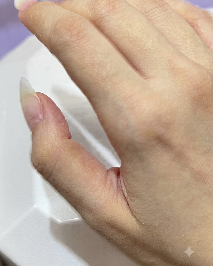 Eine Hand präsentiert saubere, unlackierte, mandelförmige Naturnägel vor schlichtem Hintergrund.