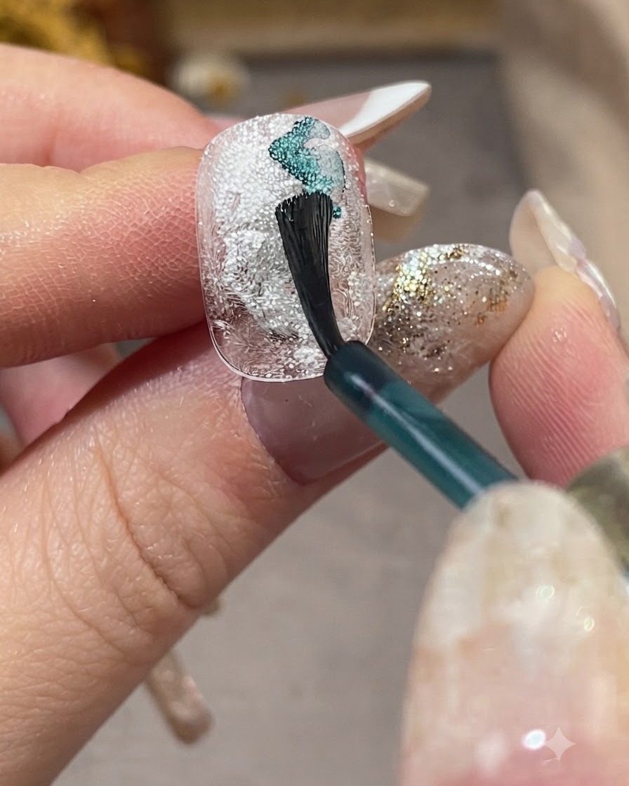 Ein Nagelpinsel trägt hellblaues Smudging-Liquid diagonal über einen strukturierten weißen Nagel auf.