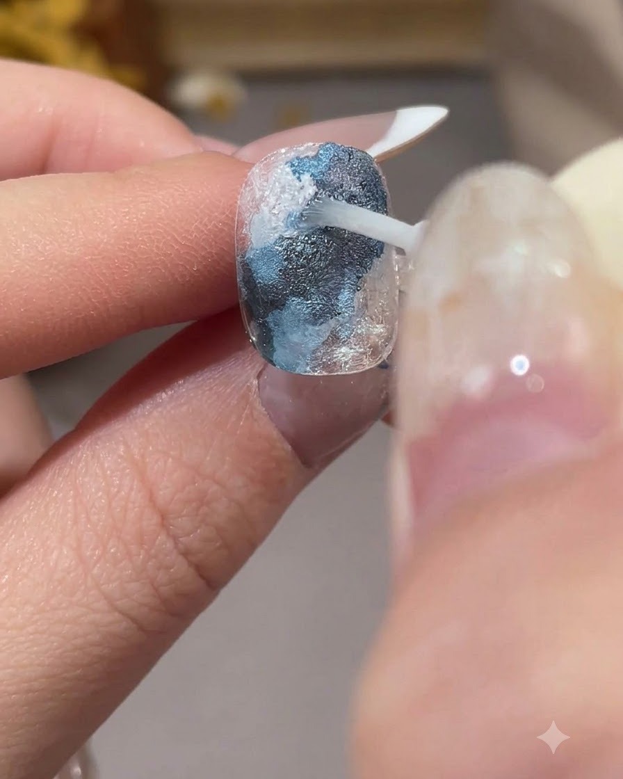 Ein Pinsel trägt transparentes Smudging-Liquid über weiße Abschnitte auf, um die Farben zu verblenden.
