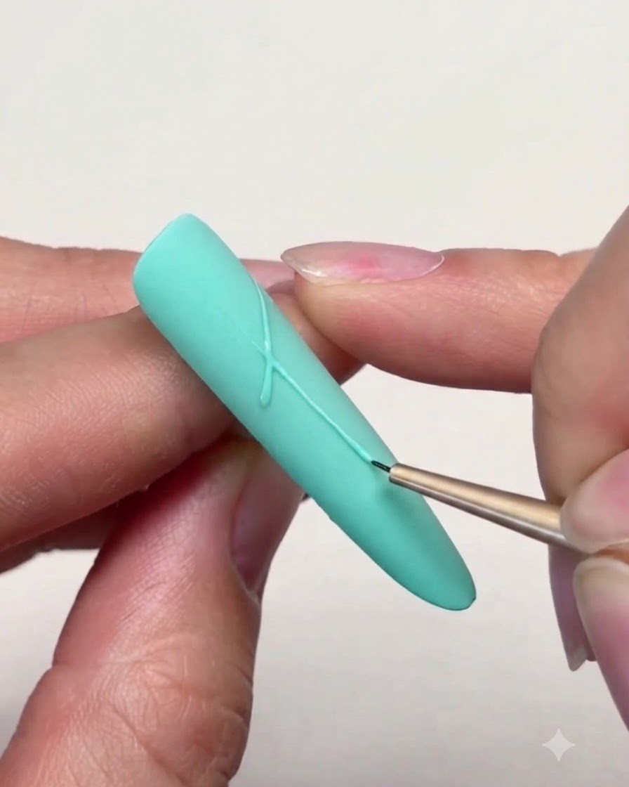 Ein feiner Liner-Pinsel, der präzise Linien zeichnet, um Sternspitzen auf einem mintgrünen Nagel zu verbinden.