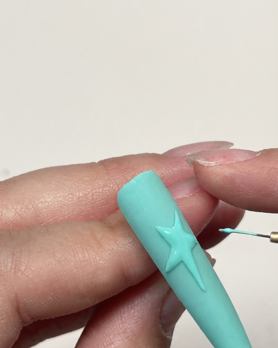 Eine detaillierte Aufnahme einer vollendeten Gelsternumrandung auf einem mintgrünen Nagel vor dem Auftragen der Textur.