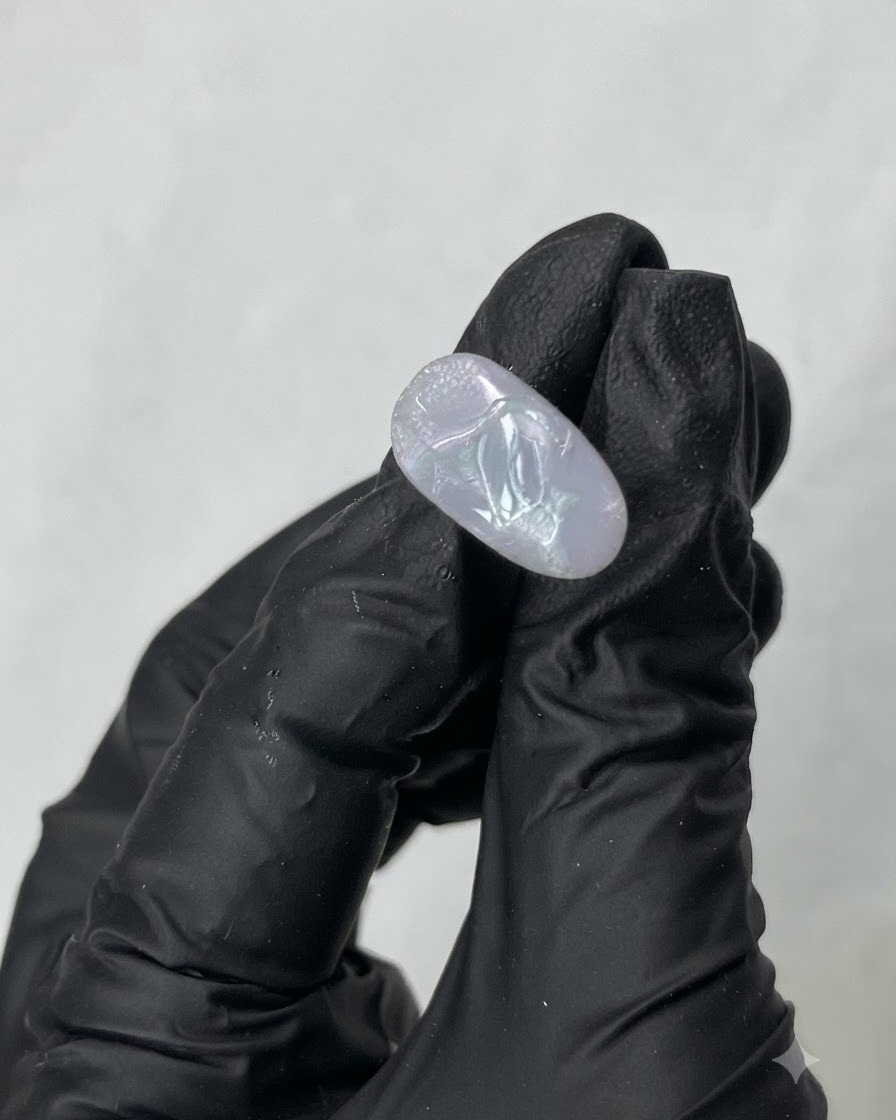 Ein Metallwerkzeug schöpft transparentes M01 Aufbaugel aus dem Inneren eines Tiegels.