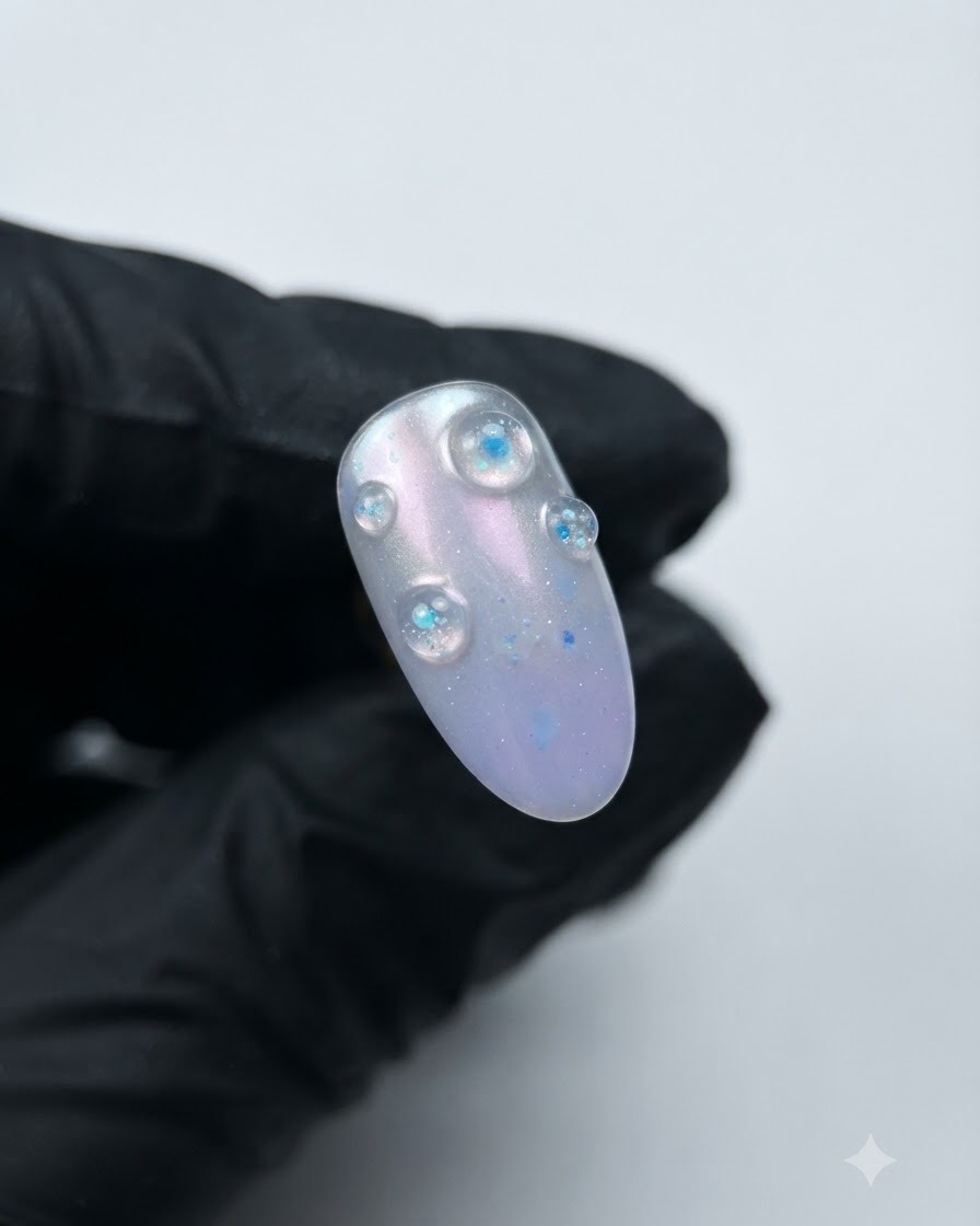 Ein fertiger Nagel mit erhabenen 3D-lila Kristall-Strukturgelblasen über einer Aurora-Basis.