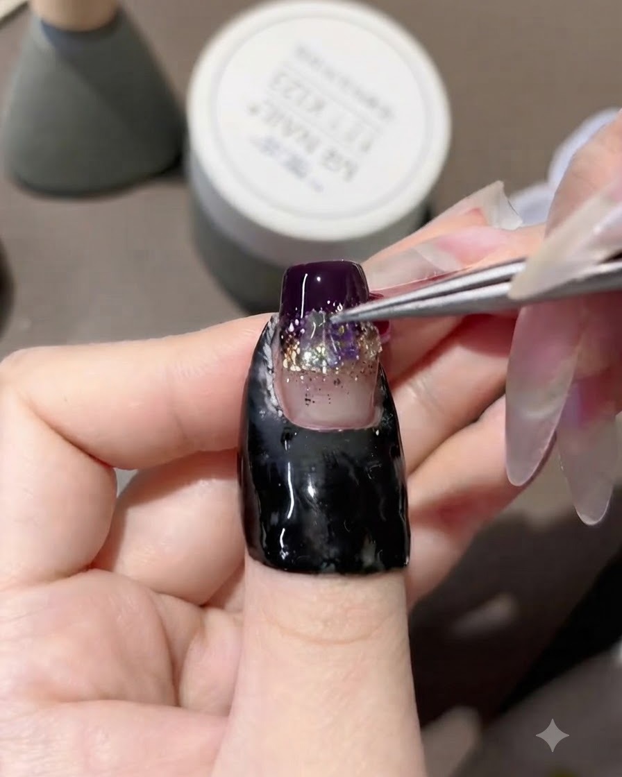Eine Pinzette platziert schillernde Aurora-Strasssteine in der Mitte eines verzierten Gelnagels.