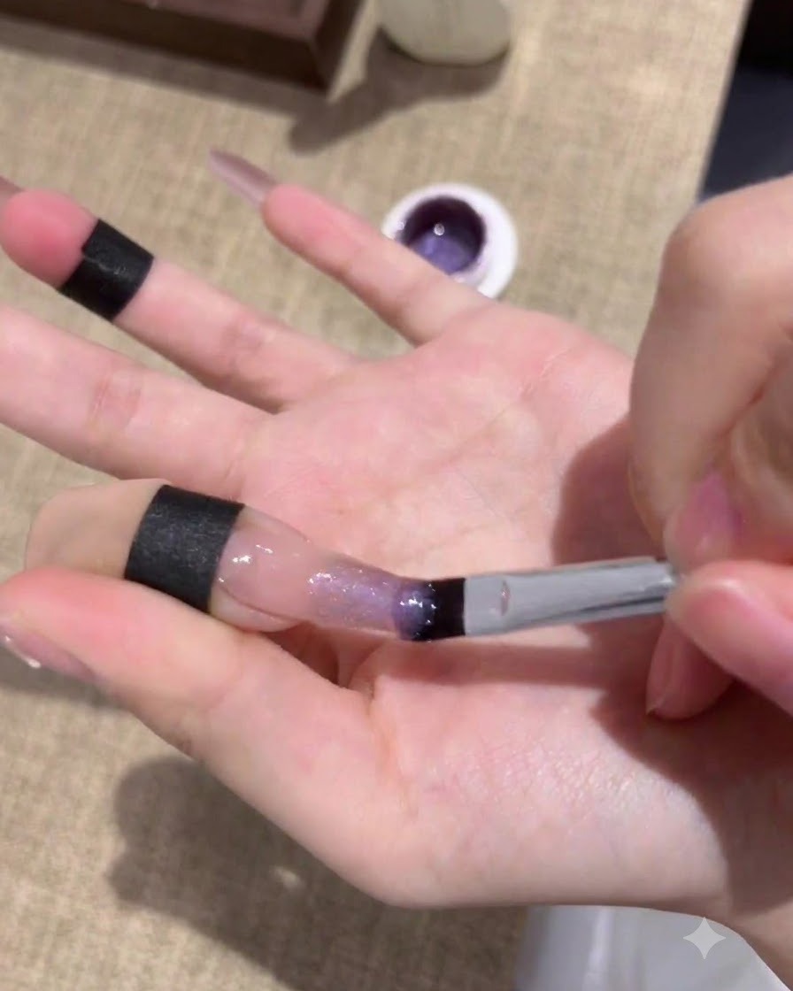 Nägel härten nach dem Auftragen der ersten Schicht violetten Cat-Eye-Gels unter einer UV/LED-Lampe aus.