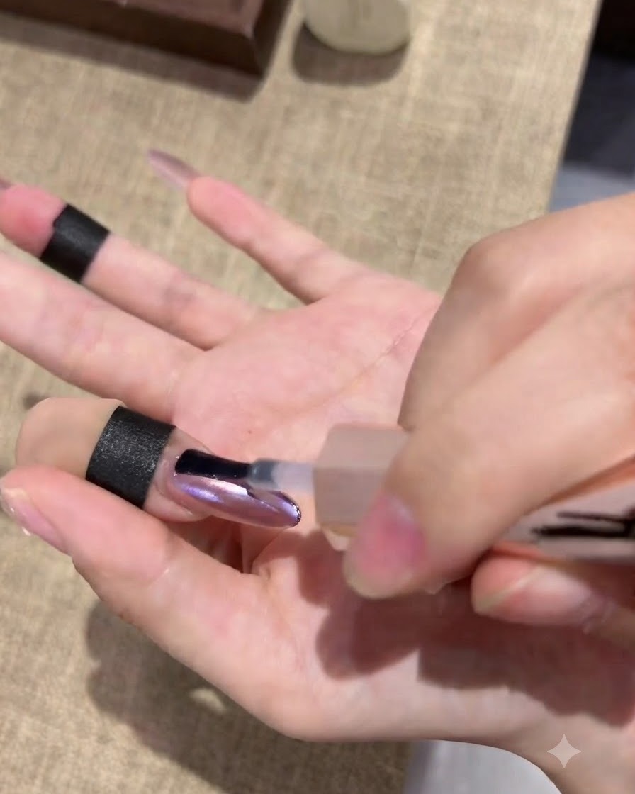 Eine Hand ruht in einer Aushärtungslampe, während die Fingerspitzen vom Licht beleuchtet werden.