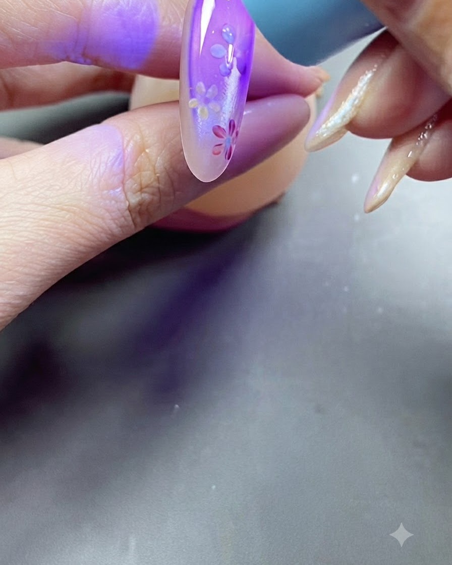 Eine Hand legt einen Nagel während des Aushärtungsprozesses unter ein violettes UV-Lampenlicht.