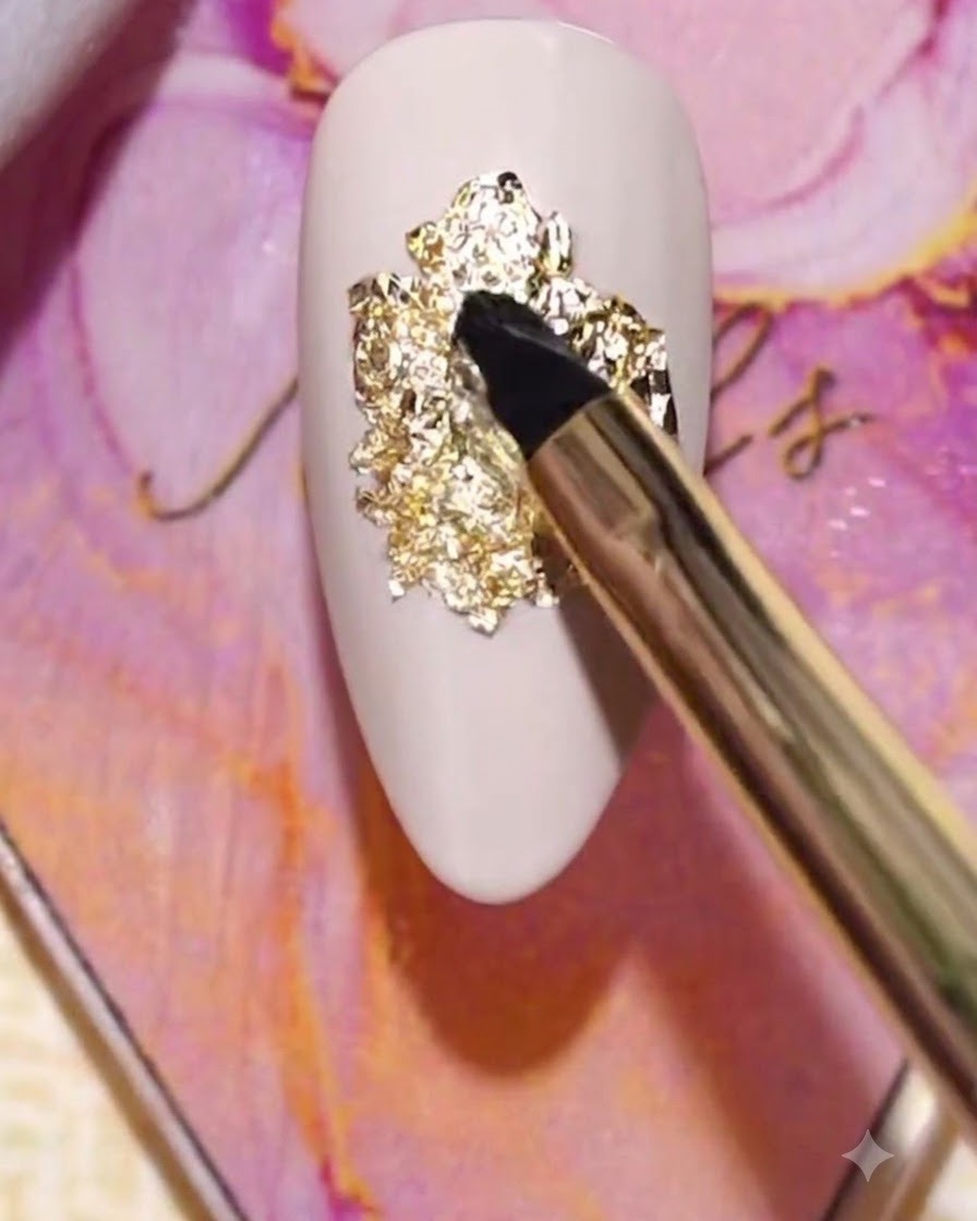 Ein Pinsel trägt eine Schicht klares Multifunktionsgel direkt über die texturierte Goldfolie auf.