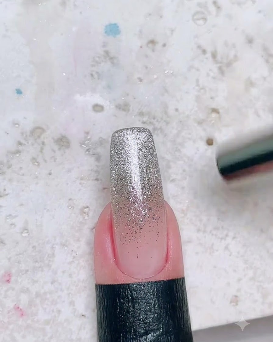 Ein Magnetstab wird neben einen mit Glitzer beschichteten Nagel gehalten, um eine Cat-Eye-Lichtreflexion zu erzeugen.