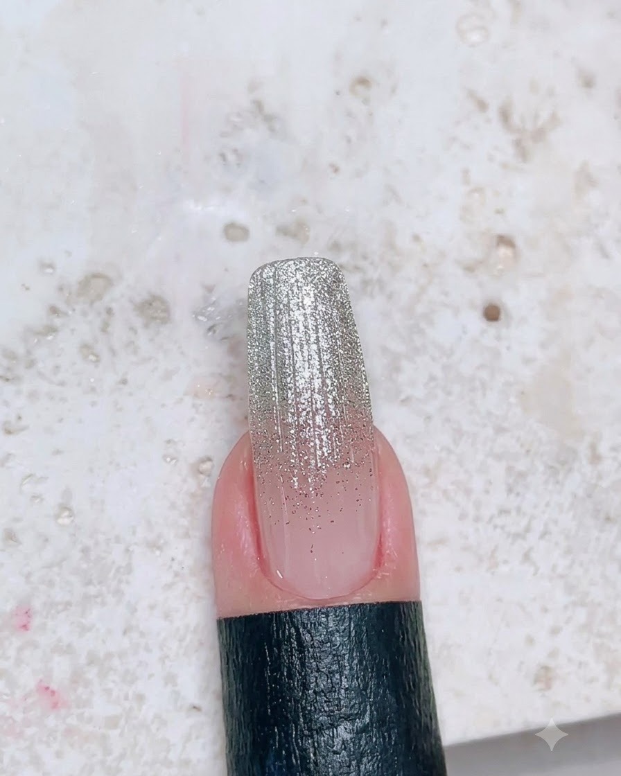 Ein Nagel mit fertigem Glitzer-Ombré-Design, überzogen mit einem glatten matten Finish.