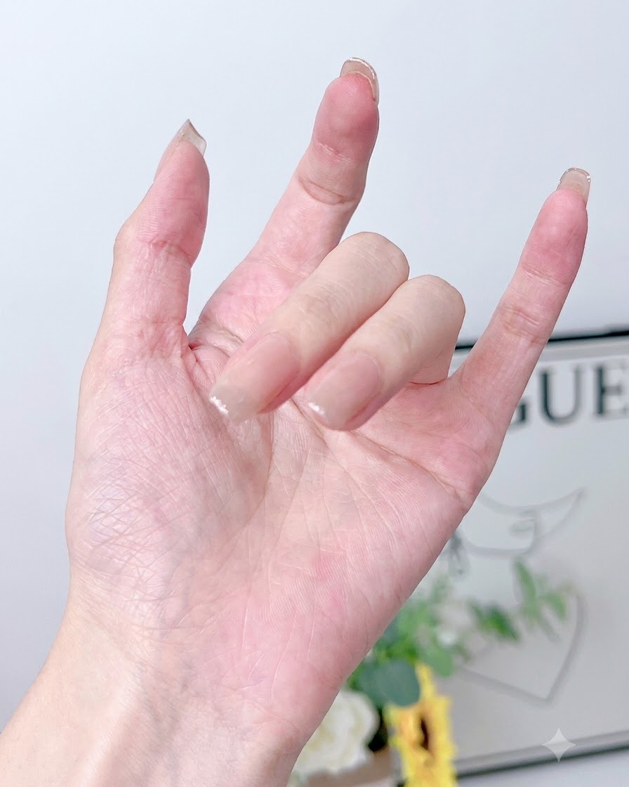 Eine Hand liegt in einer aktiven UV/LED-Nagellampe, um die aufgetragenen Gelschichten auszuhärten.