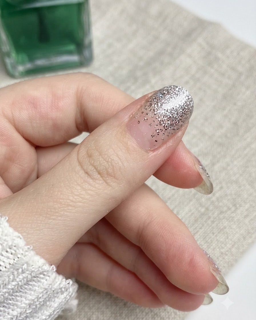 Eine Nagelfeile bewegt sich in einer Abwärtsbewegung gegen die Kante eines Daumennagels.