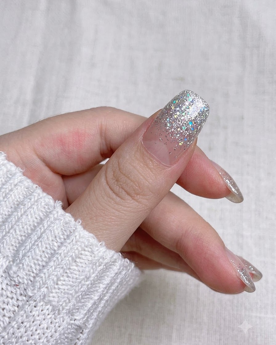 Nahaufnahme beim Trimmen des überstehenden Nagelaufkleberstreifens entlang der Spitze mit einer kleinen Maniküreschere.