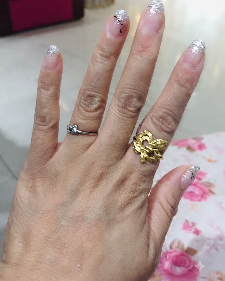 Eine Ansicht von oben auf eine Hand, die alle fünf Finger mit einem silbernen Glitzer-Gradient-Design zeigt.