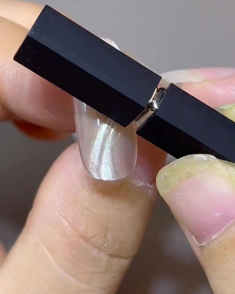 Zwei Magnete sind in einem Winkel über einem Nagel positioniert, um parallele doppelte schwebende Cat-Eye-Bänder zu formen.