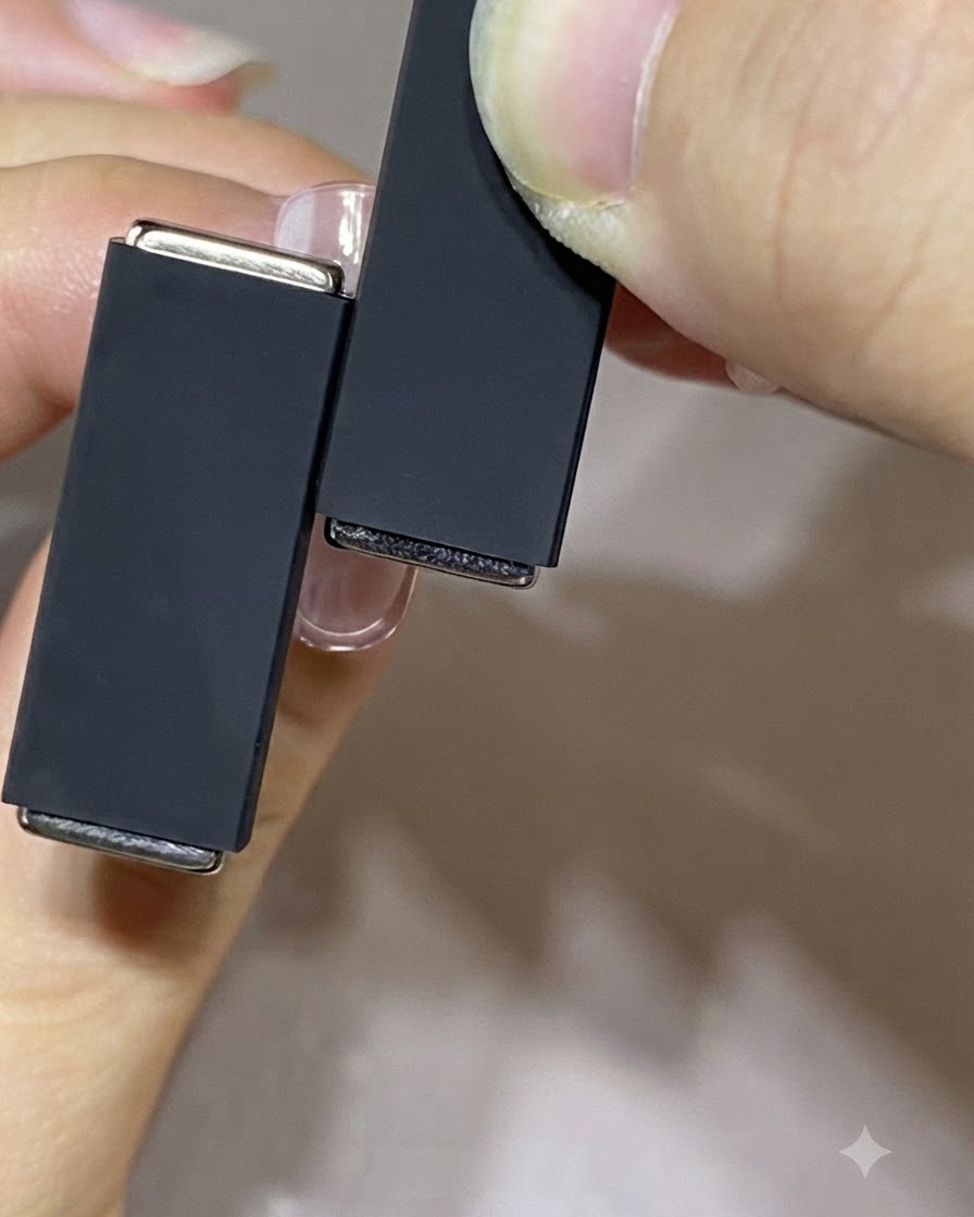 Zwei Magnete unterschiedlicher Größe werden in den Händen gehalten, um eine Technik mit mehreren Magneten zu demonstrieren.